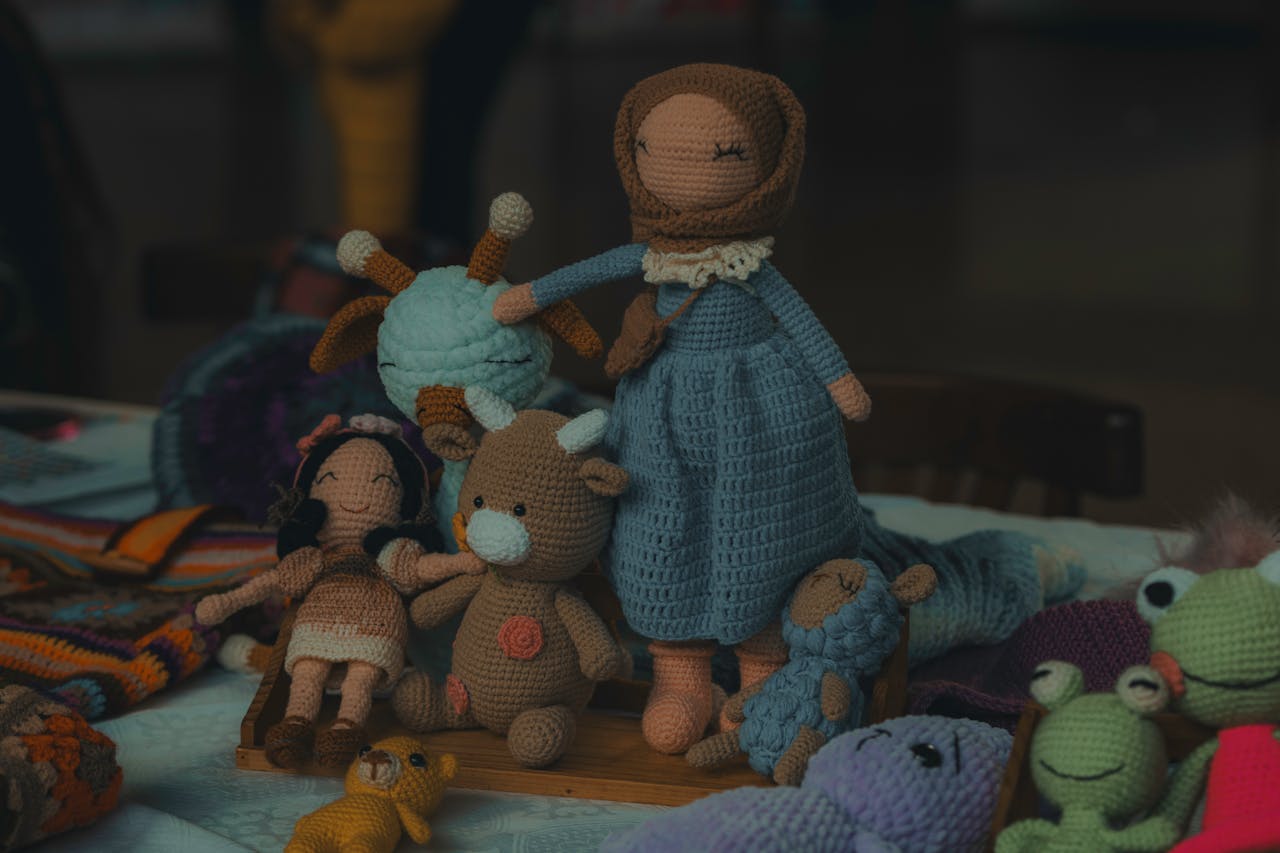 A collection of handmade knitted dolls and stuffed animals, perfect for children.